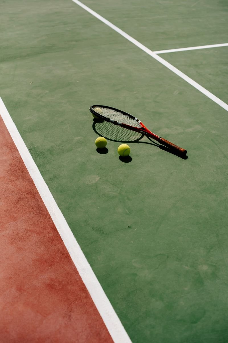 Raqueta y pelotas en una pista de tenis